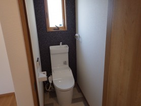 2階のトイレ。背面にモザイクタイル調の壁紙を採用。